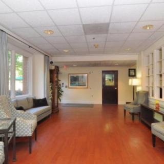 A spacious lobby with comfortable seating and warm wooden flooring.