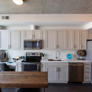 A modern kitchen with white cabinets and stainless steel appliances.