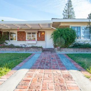 A suburban house with a brick pathway leading to the entrance.