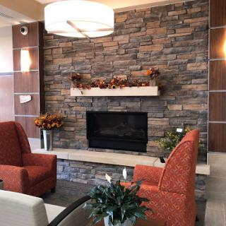 A cozy living room featuring a stone fireplace and modern furnishings, perfect for relaxation.