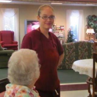 A caregiver interacting with a senior resident in a nursing home.