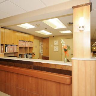 A modern reception area with wooden furniture and bookshelves.