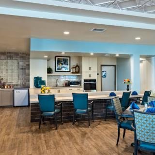 A modern interior dining area with a kitchen and seating arrangement.