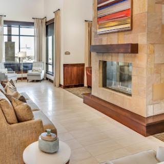 A modern living room featuring a stylish fireplace, contemporary artwork, and comfortable seating.