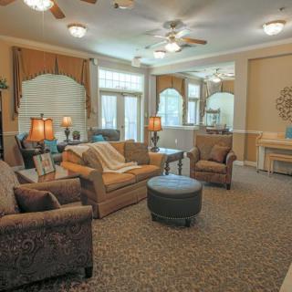 A cozy living room with comfortable seating and ample lighting.