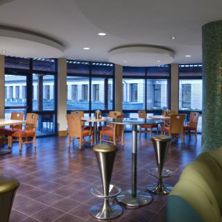 A modern restaurant interior with arranged tables and chairs in an elegant setting.