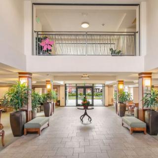 A spacious and well-decorated hotel lobby with plants and seating areas.