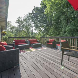 A spacious outdoor deck with comfortable seating and lush greenery.