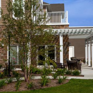 A beautiful house exterior featuring a patio with a pergola and well-maintained landscaping.