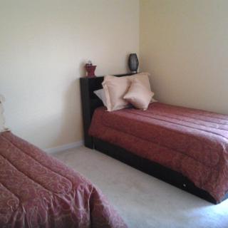 A simple bedroom with two twin beds and decorative pillows.
