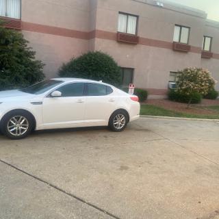 A white sedan parked in front of a building.