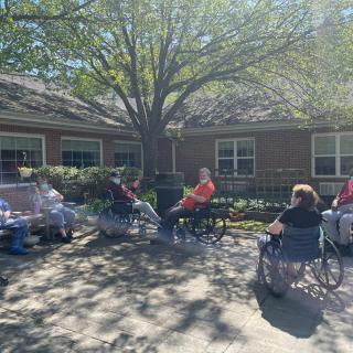 A group of seniors enjoying a sunny day outdoors in their wheelchairs.