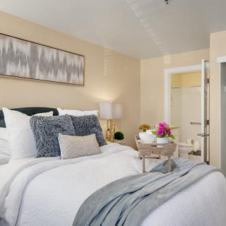 A modern and cozy bedroom with stylish decor and a tray of flowers on the bed.