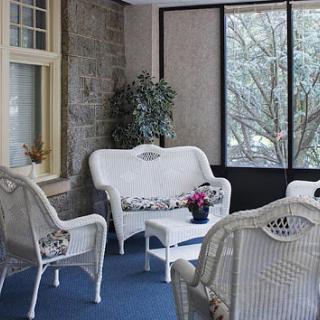 A cozy sitting area with white wicker furniture surrounded by natural light.