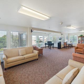 A spacious, well-lit living room with large windows and comfortable seating.