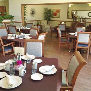 A neatly arranged dining area with tables and chairs, ready for guests.