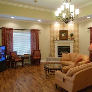 A cozy living room featuring a chandelier, fireplace, and comfortable seating.