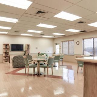 A spacious waiting room with chairs and tables arranged neatly.