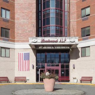 Front entrance of a hotel with an American flag displayed on the wall.