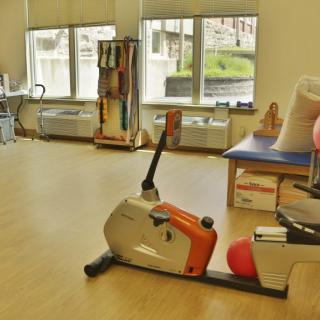 A therapy room equipped with exercise equipment, including an exercise bike.
