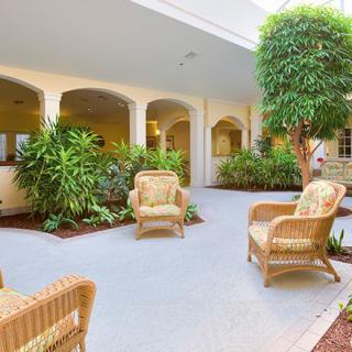 A peaceful courtyard with wicker chairs and lush greenery.