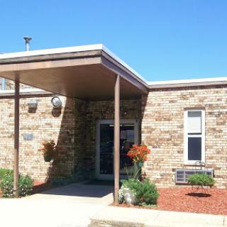 A stone-clad building with a covered entrance and well-maintained landscaping.