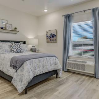 A cozy and well-designed bedroom with a neatly made bed, stylish decor, and soft lighting.