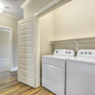 A compact laundry area with a washing machine and dryer neatly tucked behind closet doors.