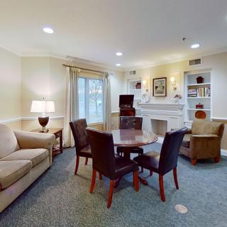 Cozy living room with a round table and chairs, sofa, and decorative elements.