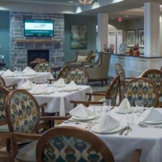 An elegantly set restaurant dining room with neatly arranged tables and chairs.