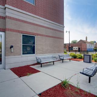 An outdoor area with benches and landscaping next to a brick building.