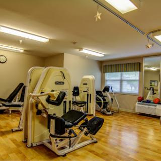 A well-equipped gym space featuring various exercise machines for fitness and rehabilitation.