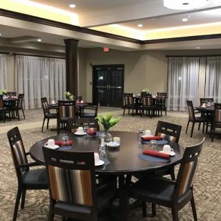 An elegant dining room setup with round tables and neatly arranged chairs.