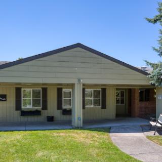 A charming single-story house with a well-maintained front yard.