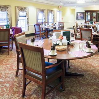 A well-furnished dining area with multiple tables and chairs arranged neatly in a bright, welcoming setting.