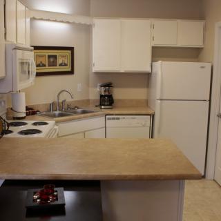 A cozy kitchen with white cabinets and modern appliances.