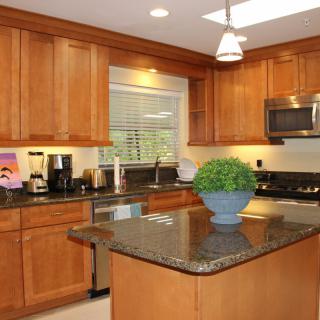 Modern kitchen with wooden cabinets and a granite island.