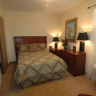 A cozy bedroom with a double bed, lamps, and decorative elements.