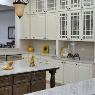 A modern kitchen featuring white cabinets, a central island, and stylish decor.