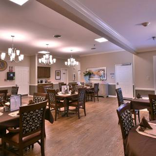 A well-lit dining area featuring elegant furniture and chandeliers.