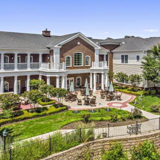A beautiful building with a landscaped garden and seating area.