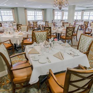 An elegant dining room setup with neatly arranged tables and chairs, prepared for guests.