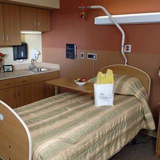 A clean and organized hospital room with a bed and bedside table.