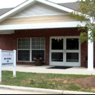 A small brick office building with a sign reading 'Office of Admissions' outside the entrance.