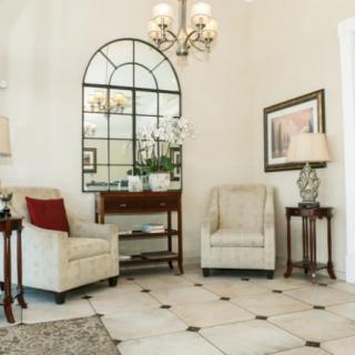 A cozy living room interior featuring two armchairs, a decorative mirror, and elegant decor.