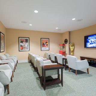 A comfortable home theater setup with rows of seating and a large television.