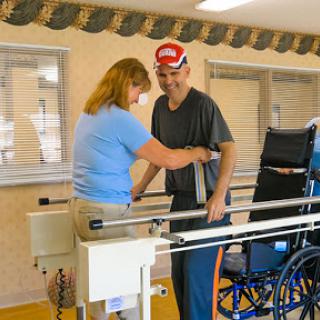 A therapist assists a patient during a rehabilitation session in a healthcare facility.