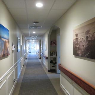 A well-lit hallway featuring artwork on the walls.