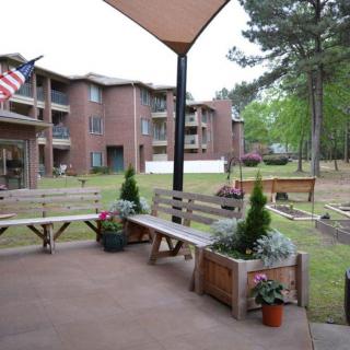 A serene outdoor patio with benches overlooking apartment buildings and greenery.