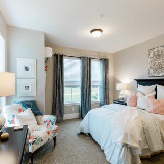 A cozy bedroom with stylish decor and ample natural light.